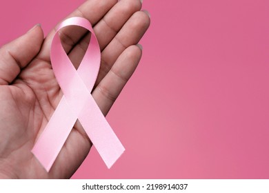 Pink October. Woman Holding Pink Ribbon On Pink Background.