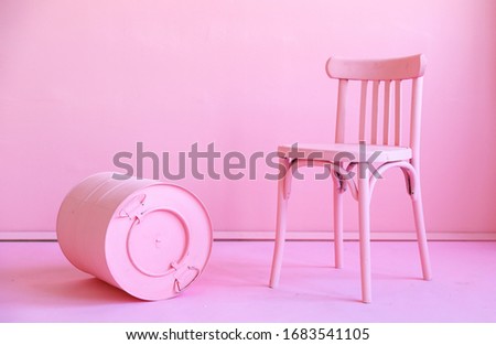 Pink old wooden chair and pink barrel isolated on a pink background. Space for text. Vacant chair. The concept of selection and casting. Minimal concept. 