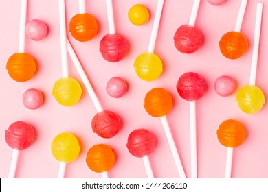 Pink, Orange And Yellow Sweet Candy Lolipop On A Pastel Pink Background