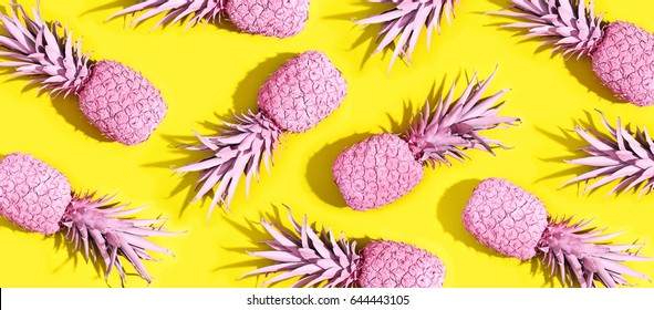Pink painted pineapples on a vivid yellow background