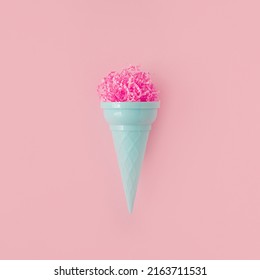 Pink paper ice cream scoop with ice cream plastic cone on bright pink background. Minimal summer concept. Micro plastic in food. Recycling.