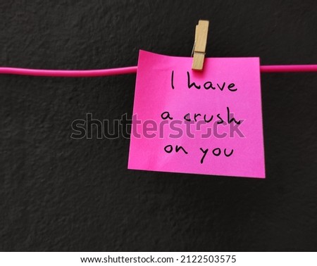 Pink paper note with handwritten text I HAVE A CRUSH ON YOU, concept of love confession on Valentines day, to tell someone have feeling of romantic love unbeknownst to that person