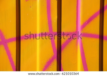 Pink pattern on yellow corrugated metal wall. Galvanized sheet background