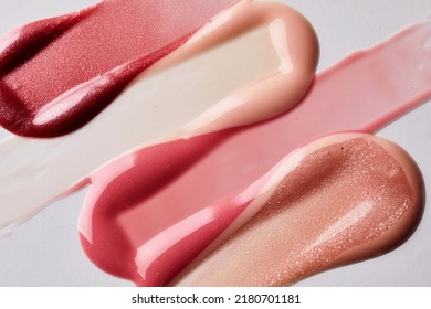 Pink, Peach And Red Lipstick Swatch On White Background With Copy Space. Lipgloss Swipe Texture,