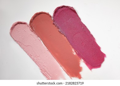 Pink, Peach And Red Lipstick Swatch On White Background With Copy Space. Lipgloss Swipe Texture,