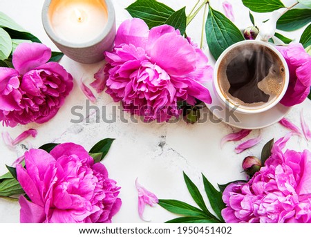 Pink  peony and cup of coffee  in beautiful style on white background. Floral background.  Top view.