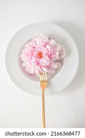 Pink Peony Flower In A White Plate With A Golden Fork On A White Background