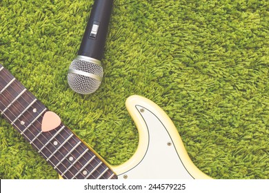  pink pick with electric guitar and dynamic microphone on green