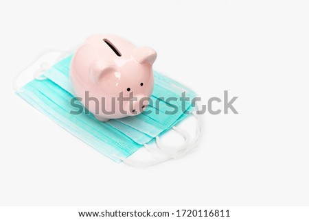 Pink pig piggy bank on a non-sterile green mask