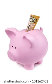 Pink piggy bank isolated on white, with Australian fifty dollar note in the slot.