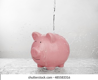 Pink piggy bank with jet of water on light background. Saving water concept