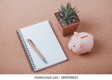 Pink Piggy Bank On Wood Office Desk Table. Saving Money Wealth And Financial Concept.