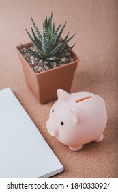 Pink Piggy Bank On Wood Office Desk Table. Saving Money Wealth And Financial Concept.