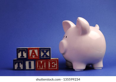 Pink Piggy Bank With Tax Time Message On Building Blocks For Tax Day Or End Of Financial Year Financial Returns Or Retail Stock-take Sales.