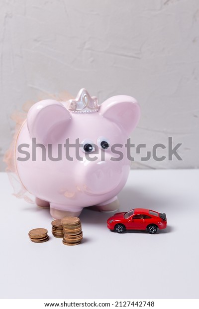 pink piggy bank, toy car and coins.\
Savings per car. financing for car loan, cheap\
car