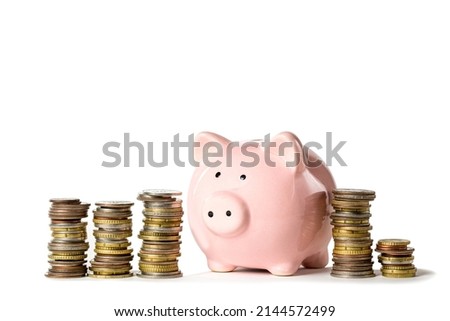 Pink piggybank near coins stacks isolated on white background. Business or finance concept