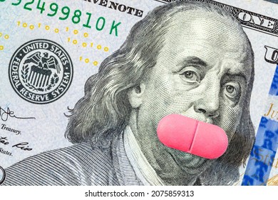 A Pink Pill Covers Franklin's Mouth On A US Hundred Dollar Bill. The Concept Of Feminism, Women's Health, The Cost Of Contraception Pills Or Conspiracy Theory