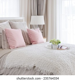 Pink Pillows On Bed With White Tray Of Flower At Home