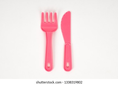 Pink Plastic Baby Fork And Knife On A White Background