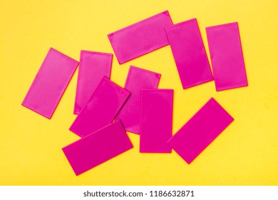 Pink plastic flat rectangles are scattered chaotically on a yellow background. Top View