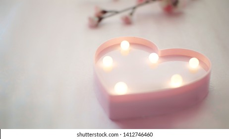 Pink plastic heart lamp on table - Powered by Shutterstock