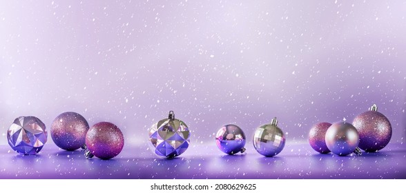 Pink and purple Christmas tree bulbs on purple background with falling snow, Christmas banner for mock up template design with copy space - Powered by Shutterstock