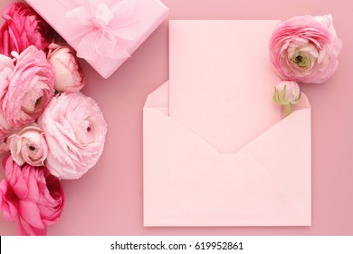  Pink Ranunculus Flowers, Gift Or Present Box And Empty Card With Envelope On Table. Mothers Day, Birthday, Valentines Day, Womens Day, Celebration Concept. Top View, Flat Lay. 

