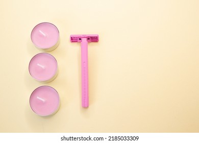 Pink Razor And Candles On Yellow Background