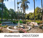 pink and red flowers in the garden surrounded by lush green trees, grass and plants at Fairmount Park with lush green palm trees in Riverside California USA