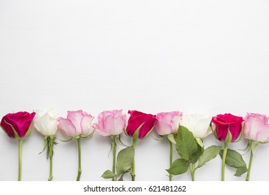 Pink and red roses on white wood background