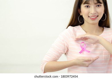 Pink ribbon affixed on an Asian woman's shirt.Do not focus on objects.World Breast Cancer Day Concept. - Shutterstock ID 1803972454