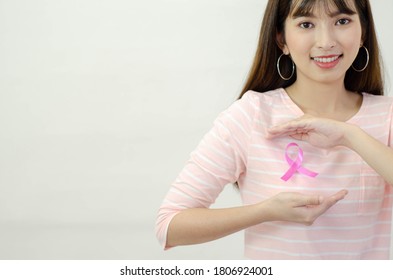 Pink ribbon affixed on an Asian woman's shirt.Do not focus on objects.World Breast Cancer Day Concept. - Shutterstock ID 1806924001