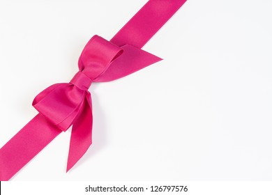 Pink ribbon and bow isolated on white