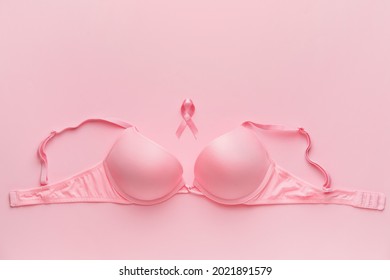 Pink ribbon and bra on color background. Breast cancer awareness concept
