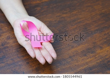 pink ribbon breast awareness in hand, concept healthcare and medical women and patient for support to take care themselves (selective focus)