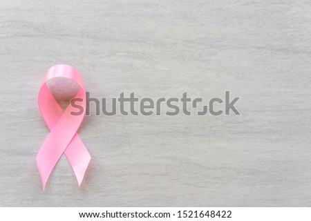 Pink ribbon, breast cancer awareness symbol, white texture background. Copy Space