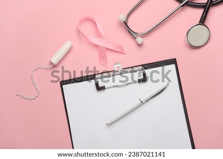 Pink ribbon, breast cancer awareness symbol with tampon, clipboard and stethoscope. Diagnostics of women's health. Top view
