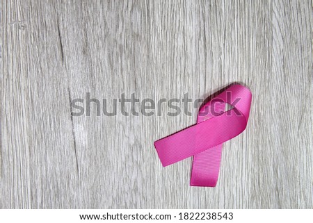 
pink ribbon for campaign against breast cancer on vintage wooden background