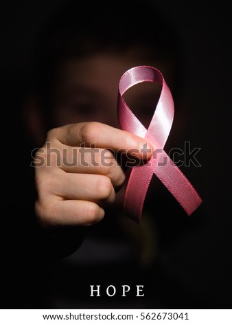 Pink ribbon color on hand, ribbon symbolic concept raising awareness support help campaign on people living life with tumor illness Breast cancer