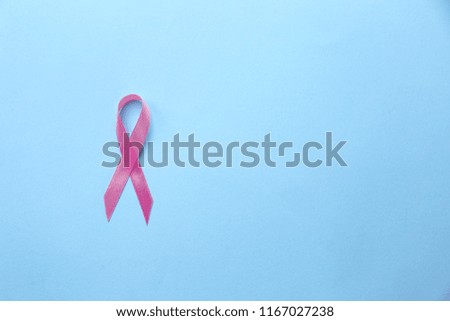 Pink ribbon on color background. Breast cancer concept