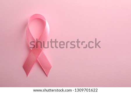 Pink ribbon on color background, top view with space for text. Breast cancer awareness concept