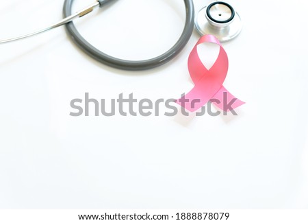 Pink ribbon and stethoscope on white background, closeup. Breast cancer awareness concept