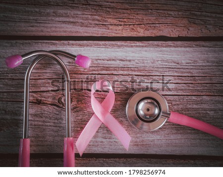 Pink ribbon and stethoscope on wooden table vintage style. Symbol of breast cancer, health care concept