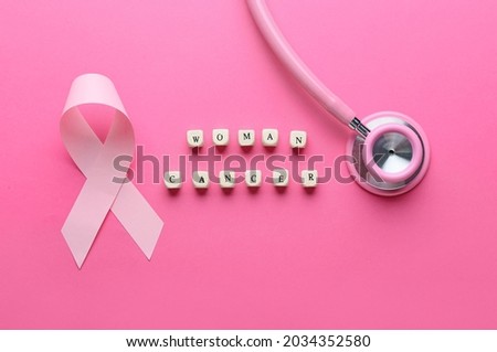 Pink ribbon, stethoscope and text WOMAN CANCER on color background