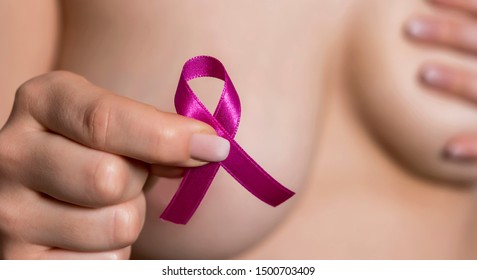 pink ribbon in woman chest to support breast cancer cause - Shutterstock ID 1500703409