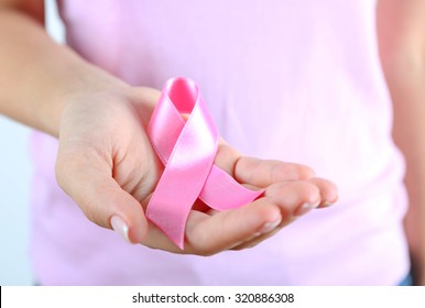 Pink ribbon in woman's hands close up - Powered by Shutterstock