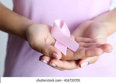 Pink ribbon in woman's hands close up - Powered by Shutterstock