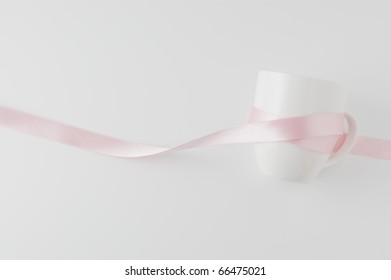 Pink Ribbon Wrapped Around The Cup Isolated On White Background