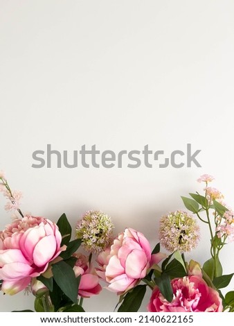 Pink Rose and Peonie Flowers with green leafs in silver vase on white table and with a white background.  Minimalistic Interior