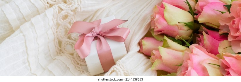 Pink Roses Bouquet With Gift Box With Pink Ribbon On Wedding Dress Backgroud